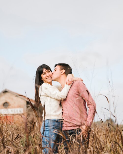 Young man kissing woman on cheek