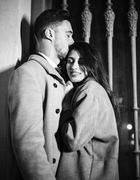 Young man kissing woman on forehead in street