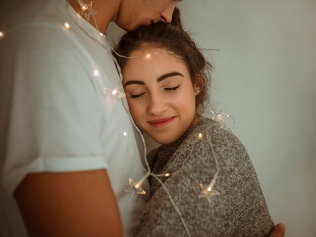 Young man kissing woman on head