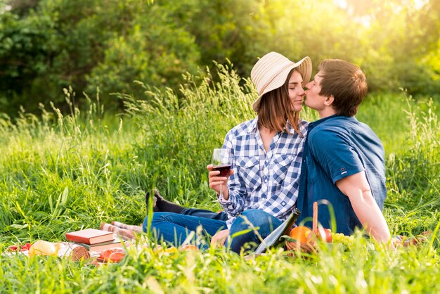 若い男がピクニックに女性にキス