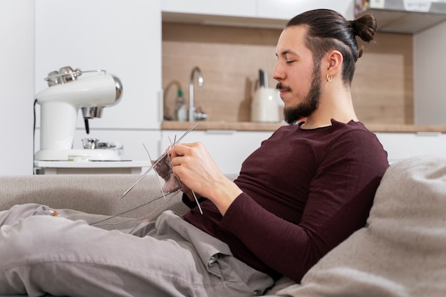 Free photo young man knitting while relaxing