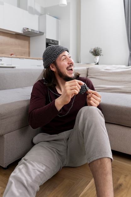 Free photo young man knitting while relaxing