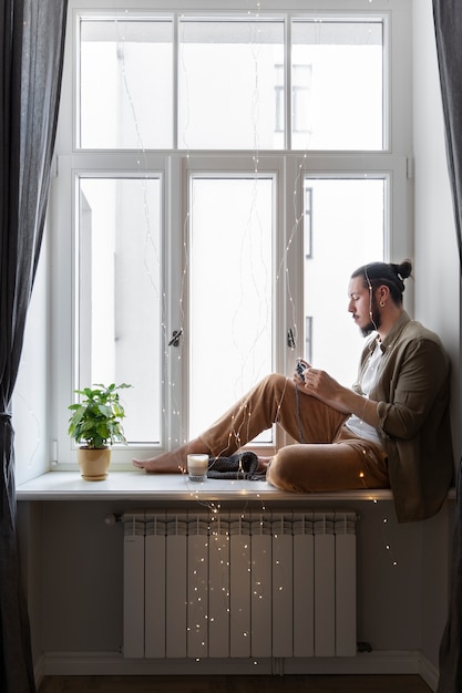 Free photo young man knitting while relaxing