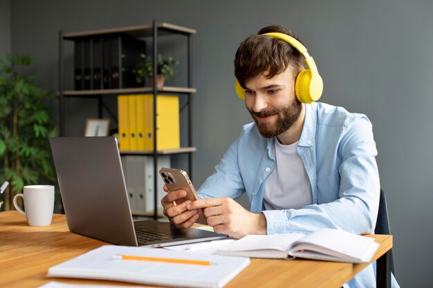 仕事中にヘッドフォンで音楽を聴いている若い男