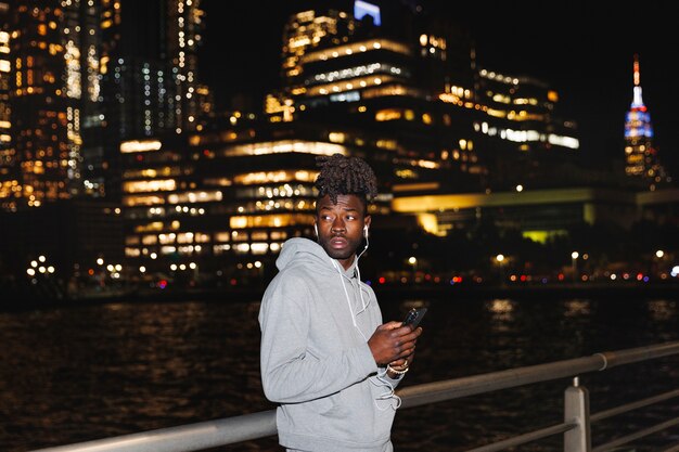 Young man listening to music at night in the city