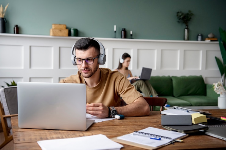 Free Photo young man listening to music during study session