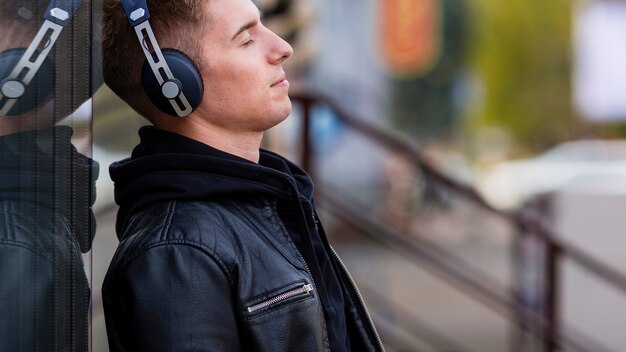 無料写真 コピースペースとヘッドフォンで音楽を聴く若い男