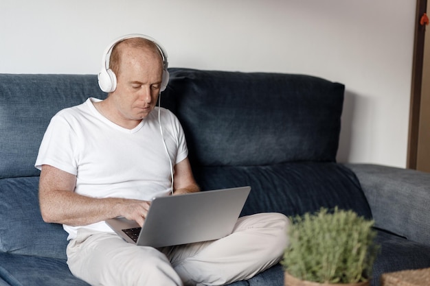 Young man listens to music and works at the computer