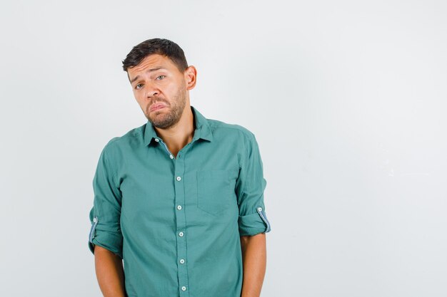 Young man looking at camera in shirt and looking offended.