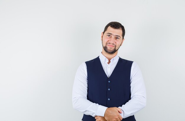 Young man looking at camera in shirt, vest and looking gentle