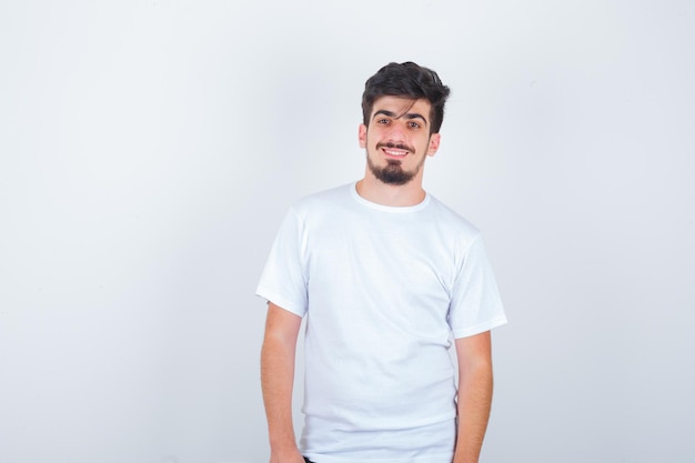 Young man looking at camera in white t-shirt and looking elegant