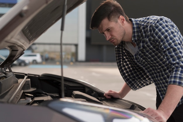 Young man looking at car