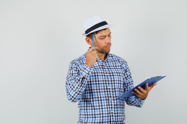 Young man looking over clipboard