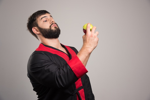 Young man looking on a fresh apple .