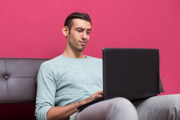 不審なとラップトップの画面を見て若い男