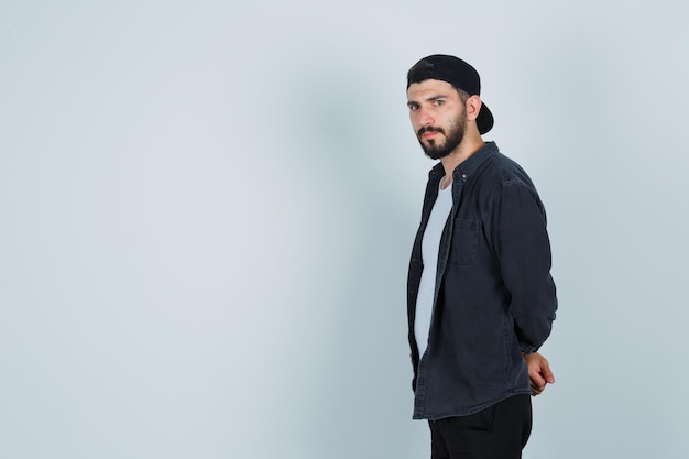 Young man looking standing sideways and looking serious