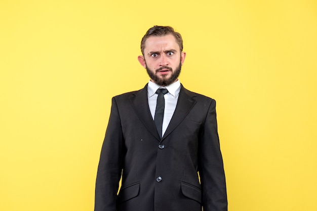 Young man looking suprised to something on yellow