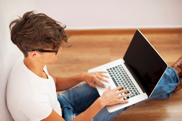 Free photo young man looking thoughtful and using laptop