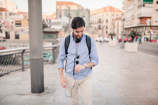 Young man looking at time on watch