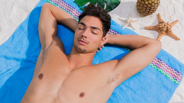 Young man lying on beach