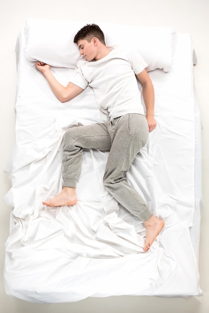 The young man lying in a bed