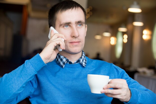 Young man making call at breakfast