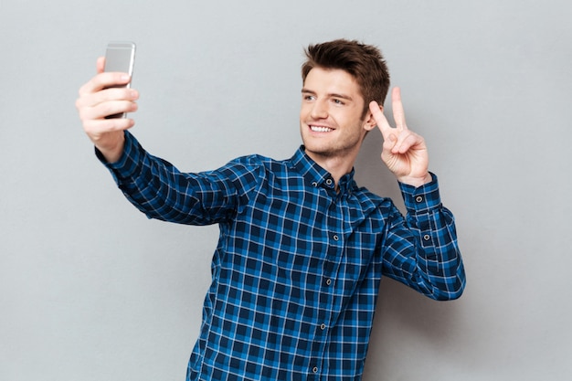 Young man making selfie using smartphone