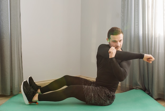 Young man making sport exercises at home