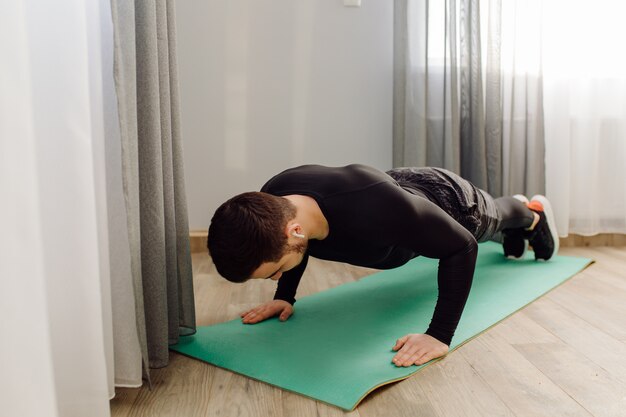 Young man making sport exercises at home