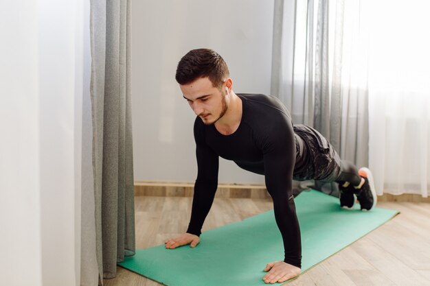 Young man making sport exercises at home