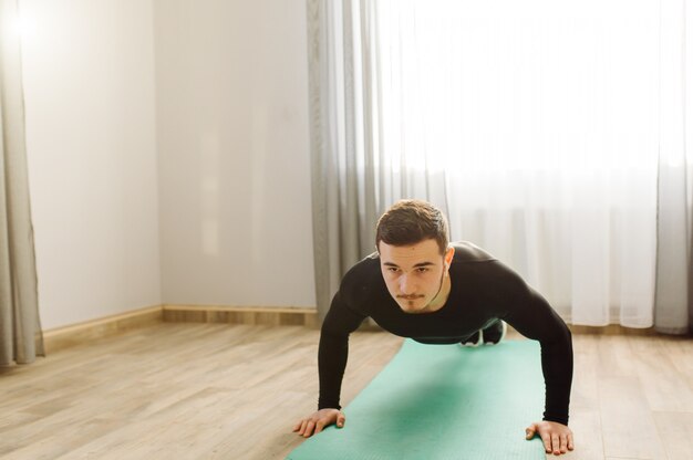 Young man making sport exercises at home