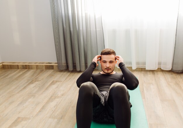 Young man making sport exercises at home