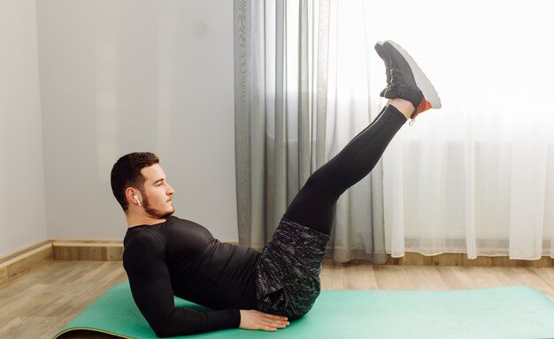 Young man making sport exercises at home