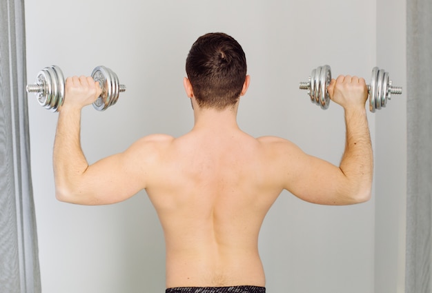 Young man making sport exercises at home