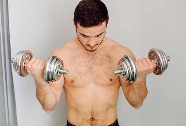 Young man making sport exercises at home