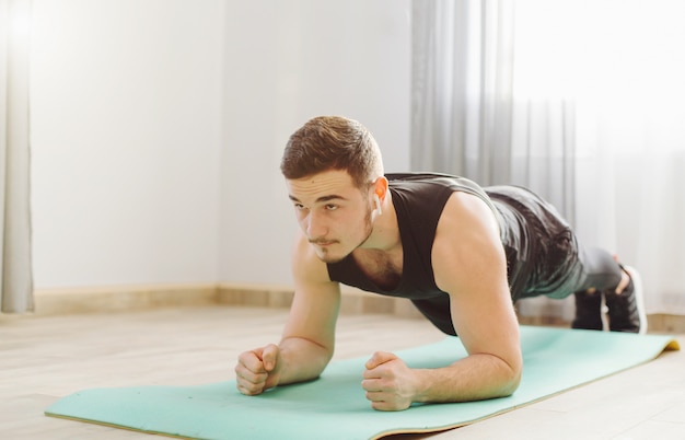 Young man making sport exercises at home