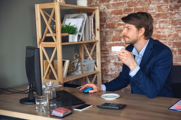 Young man, manager, team led return to work in his office after quarantine, feels happy and inspired