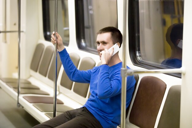 地下鉄の列車の携帯電話で若い男