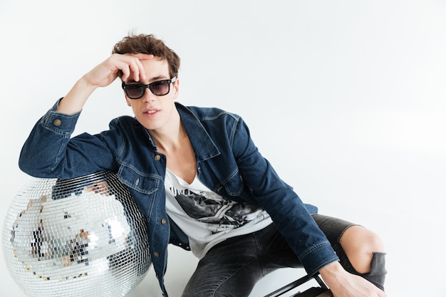 Young man near disco ball and boombox.