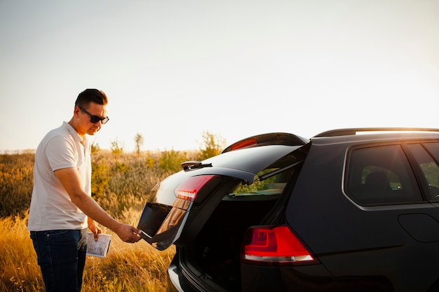 Young man opening the trunk