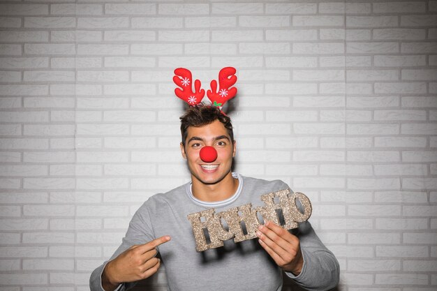 Young man in ornament deer antlers headband with sign 