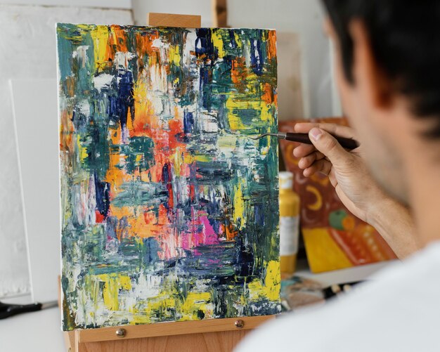 Young man painting with acrylics