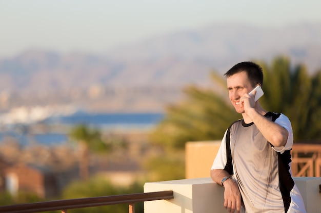 Young man on phone in sea resort