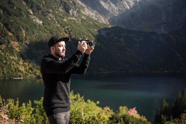 山​で​デジタル​カメラ​で​写真​を​撮る​若い​男​の​写真家​。​旅行​と​アクティブな​ライフスタイル​の​コンセプト