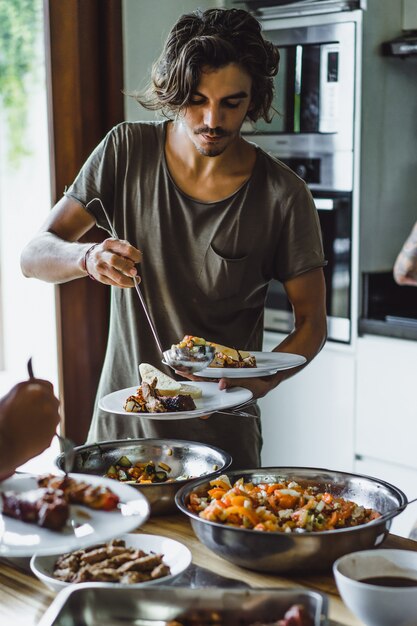 young man picks food on a plate at a party