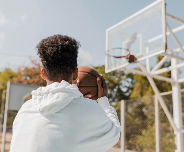 Young man playing basketball outdoors