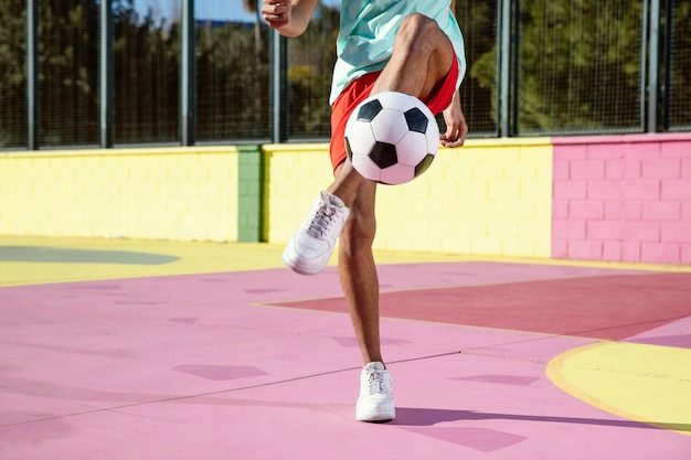 Молодой человек играет в футбол крупным планом