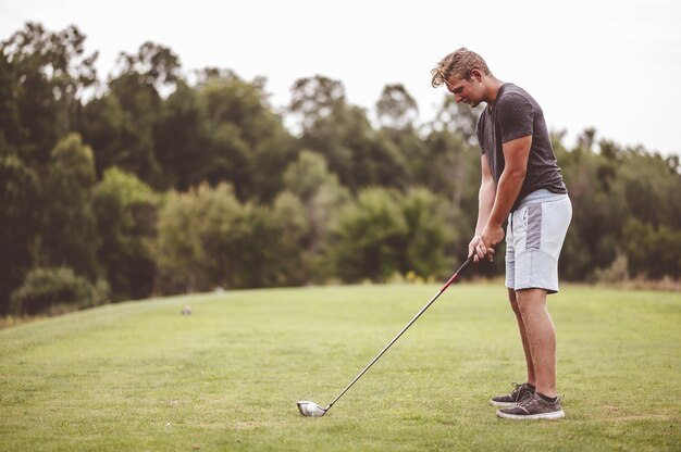 ゴルフをしている若い男