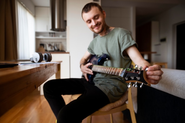 Young man playing guitar at home