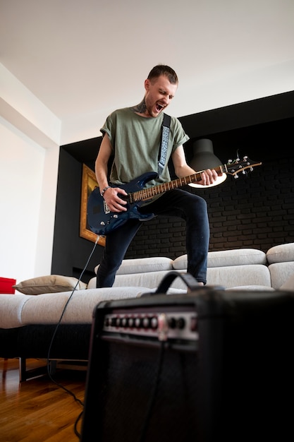 Young man playing guitar at home